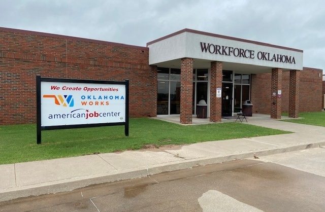 Brick exterior building with sign above door "Workforce Oklahoma". Sign to the left of the door that states "We Create Opportunities" with the Oklahoma Works Logo.